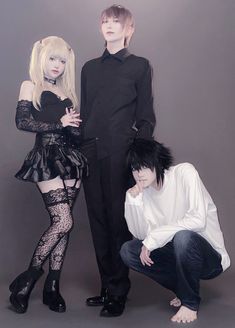 three people dressed in black and white posing for a photo with one person wearing tights