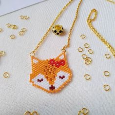 a cross stitch necklace with a fox head on it