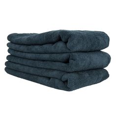 four towels stacked on top of each other in dark blue color, one folded and the other rolled up