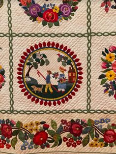 a quilted wall hanging with flowers and people in the center, surrounded by green trimmings