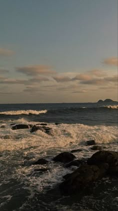 two surfers are standing on the rocks near the ocean