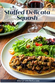 an image of stuffed delicata squash on a plate with salad in the background