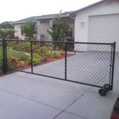 a fenced in yard with a car parked next to it and a house on the other side