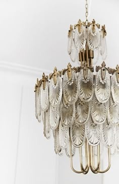 a chandelier hanging from the ceiling in a room with white walls and flooring