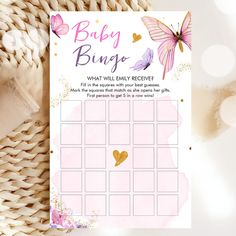 a pink and gold baby shower game with butterflies on the side, sitting next to a wicker basket