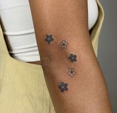 a woman's arm with four clover tattoos on it