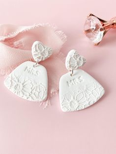 Discover Mrs. Earring, the perfect choice for bachelorette party jewelry for the bride to be. These handmade clay bridal earrings feature white floral dangles, making them an ideal bridal shower gift. ✨Earring Details✨ - Polymer clay - Earring posts are stainless steel & hypoallergenic - Lightweight Want to see more of our bridal earrings? Click the link ⬇ https://www.etsy.com/shop/Wild4Style?ref=seller-platform-mcnav&section_id=43807854 📦Shipping & Packaging📦 All orders will be packaged securely to ensure a safe delivery. Orders will be processed and shipped within 1-7 business days.  If you need it sooner, I provide a rush order option.  The rush order option, expedites the processing and shipping to 1-3 business day.  If you would like to add this to your order, click the link below. Bridal Clay Earrings, Clay Earrings Wedding, Jewelry For Bride, Earring Bridal, Bridal Earring, Earrings Ideas, Polymer Earrings, Bride Earrings, Clay Earring