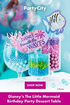 the little mermaid party decorations are on display in glass vases with colorful candies