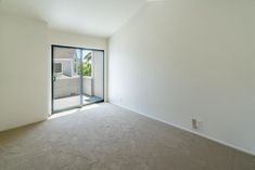 an empty room with sliding glass doors and carpet