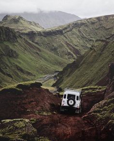 an off - road vehicle driving through the mountains on its way to the water hole