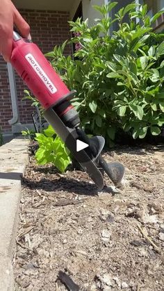 someone is using a garden shear to cut up the ground in front of their house