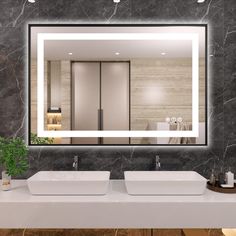 a bathroom with two sinks and a large mirror on the wall above it that is illuminated by lights