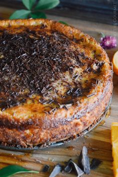 a cake sitting on top of a wooden table next to sliced oranges