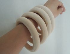 a person's arm with several wooden rings on it, all wrapped around one another