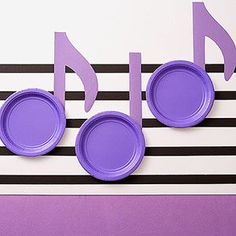 purple paper plates with musical notes on them are arranged in the shape of music notes