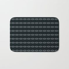 a black and white bath mat with an intricate design on it, in the shape of a chain