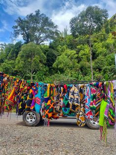 there is a truck that has many colorful items on the side of it and some trees in the background