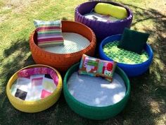 several different colored chairs and cushions in the grass