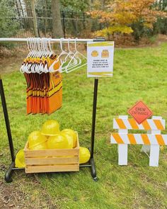 an orange and yellow shirt is hanging on a rack next to other items in the grass