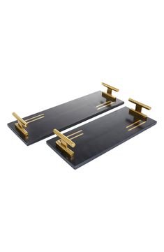 two black trays with gold handles on them