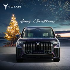 a car parked in front of a christmas tree with fireworks on the sky behind it