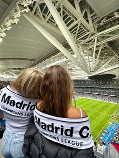 two women sitting in the stands at a soccer game