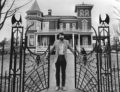 a man standing in front of a large house