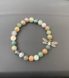 a beaded bracelet with a gold bee charm and multicolored beads on it