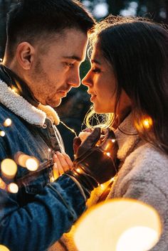 a man and woman standing next to each other with lights on their foreheads in front of them