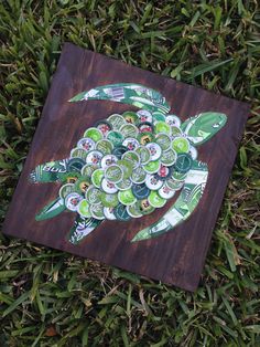 an image of a turtle made out of beer bottle caps on wood planks in the grass