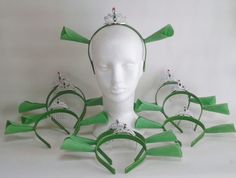 a white mannequin head with green ribbons and tiaras