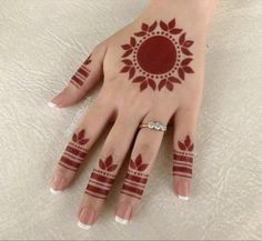 a woman's hand with hennap and ring tattoos on her left hand