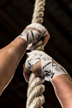 two hands holding on to ropes in a building