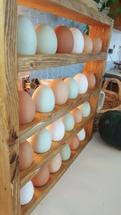 several eggs are stacked on top of each other in a wooden rack with wire around them