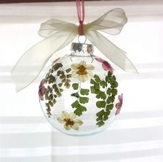 a glass ornament with flowers and leaves on it