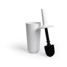 a white cup with a black brush in it next to a tall plastic cup on a white background