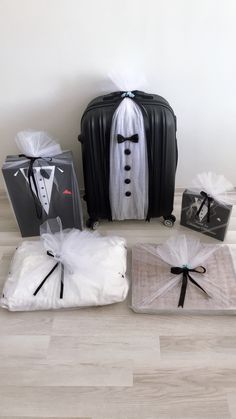 three pieces of luggage sitting on top of a floor next to each other with ties and tuxedo