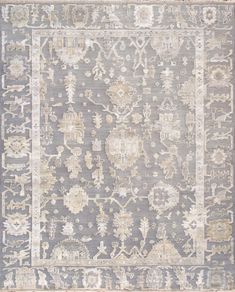 a gray rug with an ornate design on the top and bottom, in various colors