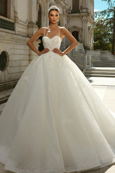 a woman in a white wedding dress posing for the camera with her hands on her hips