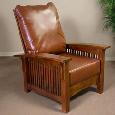 a brown leather chair sitting in front of a potted plant on top of a carpeted floor