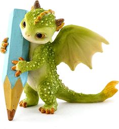 a toy dragon holding a pencil and writing on it's back with its wings spread