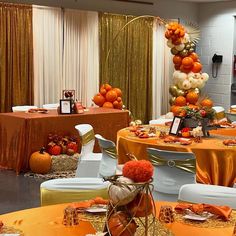 an orange and white table setting with gold sequins, pumpkins and other decorations