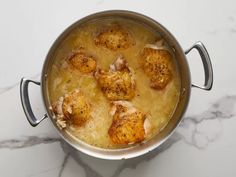 a pot filled with some kind of food on top of a white marble countertop