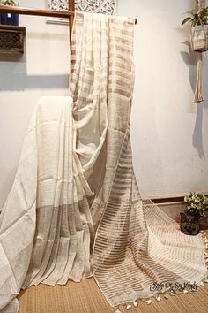 Organic tissue linen saree with zari stripes with blouse piece. Step into elegance with our sophisticated tissue linen sarees, adorned in blissful off white that exude timeless charm. Crafted with airy, breathable handspun and handwoven linen fabric, this saree ensure comfort while making a striking statement with their unique silver zari stripes. Perfect for any occasion, from casual gatherings to formal events, these sarees are versatile and effortlessly stylish. this saree comes with a running blouse piece. Elevate your wardrobe with these exquisite pieces that blend luxury with comfort seamlessly. Details: Blouse: With Blouse Piece Saree length: 6.5 meters [BP Include] Saree width: 47 inches Material:  Organic linen [100 counts] work: handwoven Fall & Picot: You do not need any extra e Elegant White Slub Silk Saree, Wedding Linen Saree With Handloom Detail, Festive Wedding Linen Saree, Festive Linen Handloom Saree, Festive Handloom Linen Saree, Traditional Linen Handloom Saree, Elegant White Handloom Dupatta, Zari Saree, Linen Sarees