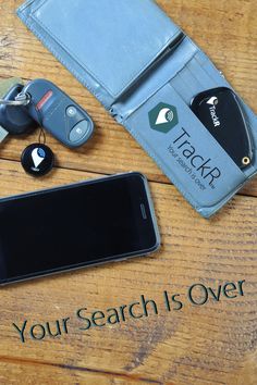 a cell phone sitting on top of a wooden table next to a wallet and keys