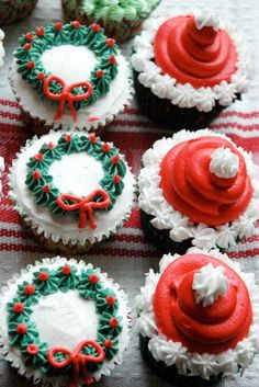 cupcakes decorated with red, green and white frosting are arranged on a table