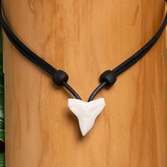 Necklace with a real tooth from a bull shark, absolutely no-frills design - just a black leather strap, shark tooth and nothing else. The shark tooth has a size of approx. 2 cm. We only use extra sturdy cowhide leather, which is particularly stable and tear-resistant. The chain can be variably adjusted using two wooden beads (left and right in the picture) and therefore fits any neck size. The adjustment range is between 35 and 65 cm, and the desired length can be easily adjusted within seconds. We manufacture all of our items by hand in our own workshop near Berlin. HANA LIMA - finest handmade beach & surf jewelry Surf Jewelry, Bull Shark, Beach Surf, Mens Chain Necklace, Shark Tooth, The Shark, Shark Teeth, Men's Necklace, Leather Chain