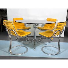 four yellow chairs are around a glass table