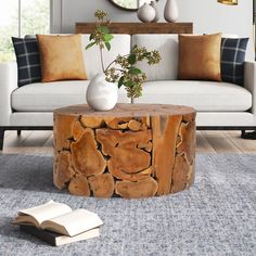 a wooden table sitting on top of a carpeted floor next to a white couch