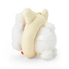 a white stuffed animal with a banana on it's back and its tail curled up